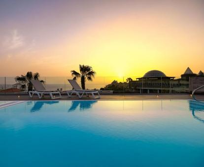 Foto de la piscina con tumbonas y vistas al mar de este hotel.