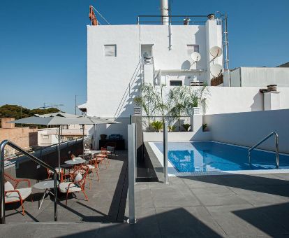 Agradable terraza con mobiliario y piscina con vistas de este elegante hotel romántico.