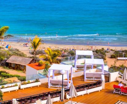 Foto de la zona de relajación del hotel con camas balinesas y vistas al mar.