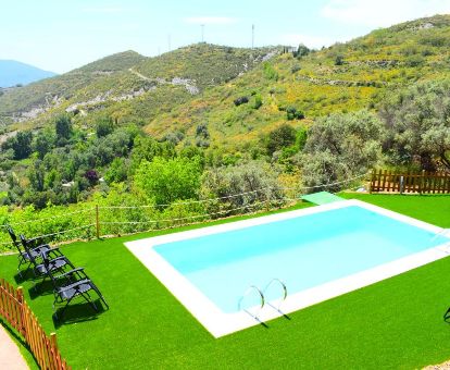 Agradable espacio exterior con piscina, solarium y vistas a la naturaleza de este complejo rural de apartamentos.