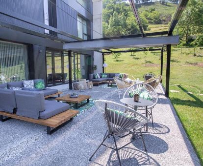 Agradable terraza con mobiliario y vistas a la naturaleza que rodea este moderno hotel.