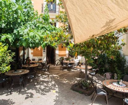 Agradable terraza con comedores exteriores de este acogedor hotel ideal para parejas.