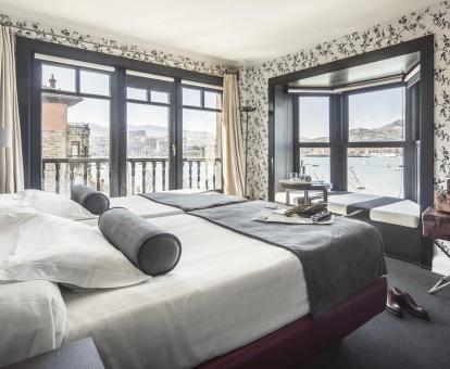 Foto de una de las habitaciones con asiento junto a la ventana y hermosas vistas al mar.