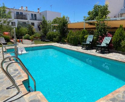 Acogedor espacio exterior con piscina, solarium y jardín de este alojamiento rural.