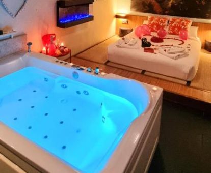 Dormitorio con un gran jacuzzi privado junto a la cama de uno de los preciosos apartamentos de este hotel.