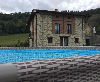 Edificio con amplios jardines y piscina en un tranquilo entorno natural, ideal para descansar del bullicio.