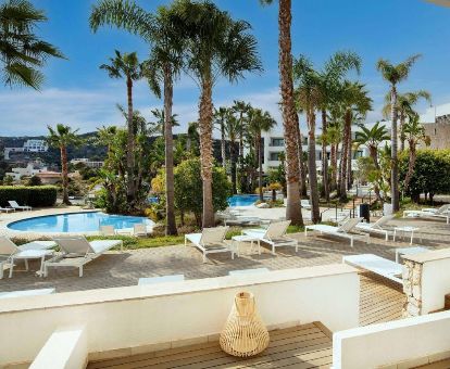 Exteriores de este romántico hotel con piscina rodeada de jardines.