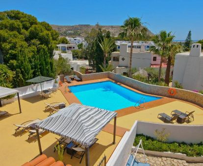 Terraza solarium con piscina al aire libre y vistas de este hotel solo para adultos.