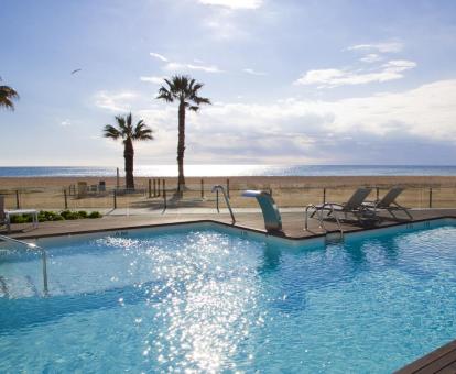 Foto de la piscina al aire libre con chorros de hidroterapia con vistas a la playa y al mar.