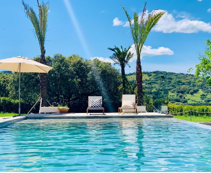 Fabulosa piscina exterior que cuenta con una hermosa vista hacia las colinas Casa Rural Alronocalejo en Monesterio
