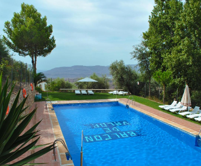 Piscina al aire libre rodeada de hermosos arboles de la casa Balcón de Válor en Válor