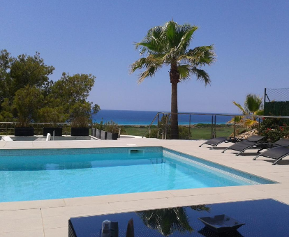 Piscina al aire libre con hermosa vista a la playa Son Bou en la Villa Boramar en Son Bou