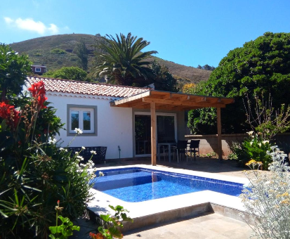 piscina al aire libre cercada por hermosas flores y plantas de la Casa Domi en La Esperanza