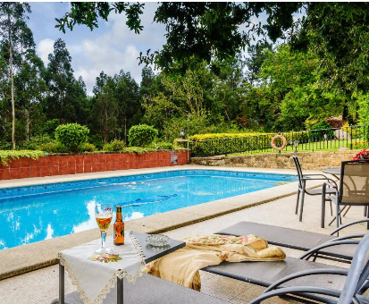 Fabulosa piscina exterior rodeada de una hermosa vegetacion Casa rural dos Celenis en Caldas de Reis
