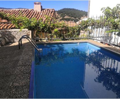 Piscina rectangular de exterior con vista al pueblo de Tronchón en la Casa Rural Conesa I