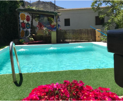 Piscina exterior ubicada en las adyacencias del jardín de la Casa Cortijo en Bubión