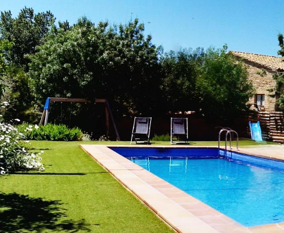 Piscina exterior cerca del jardín y del parque infantil de la casa Cozy Cottage en Olíus