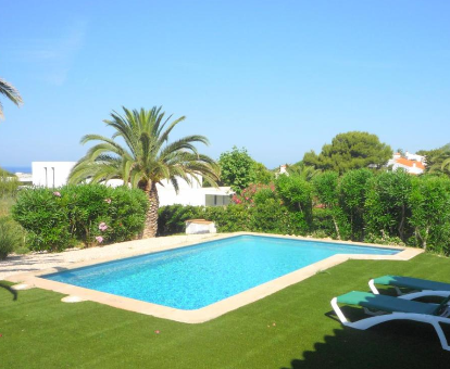 Piscina exterior ubicada en el medio del jardín de la Villa Cristina Binibeca