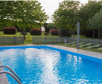 Hermosa piscina al aire libre ubicada al lado del jardín de la Casa Do Neto en Mato