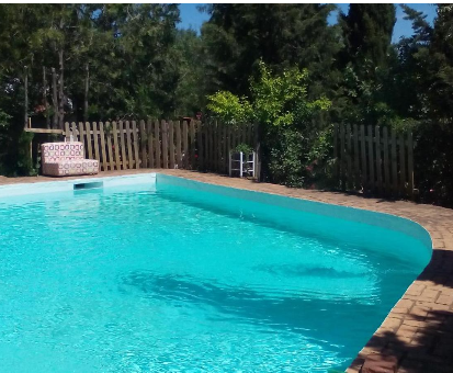 Piscina al aire libre ubicada en las adyacencias del vergel de la Casa Cortijo El Berrocal en Cazalla de la Sierra