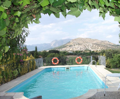 Hermosa piscina en jardín con una majestuosa vista hacia las altas montañas. Cabañas Cortijo el Helao en Pozo Alcón
