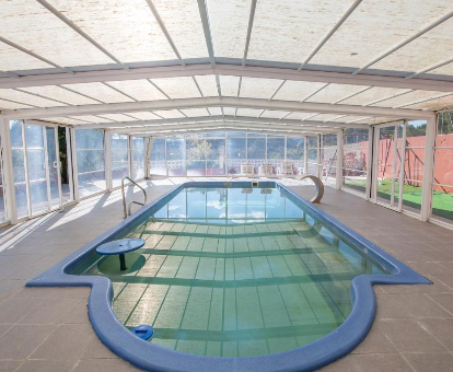 Amplia piscina exterior techada y con fuente de agua de la Casa El Mirador en Teruel