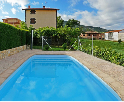 Piscina exterior situada al lado del jardín de los Apartamentos Rurales El Prado en Pinofranqueado