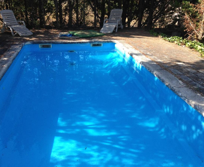 Piscina al aire libre situado en el medio del jardín de la casa El Refugio en teruel