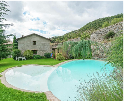 Piscina exterior alojada en el medio del jardín de la casa Espunyes Oden