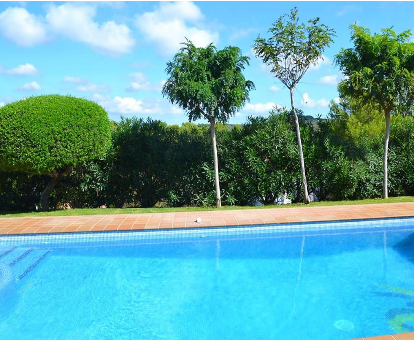 Piscina exterior rodeada de una hermosa floresta en el chalet Villas Finesse en Son Bou 