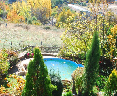 Magistral piscina al aire libre rodeada de un hermoso jardín florístico. Casa Rural Jardines del Robledo en San Miguel del Robledo