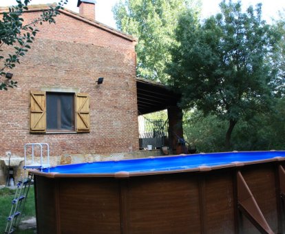 Hermosa piscina de madera exterior rodeada de una verdosa vegetación. Casas Rurales La Aceña de Huerta en Huerta