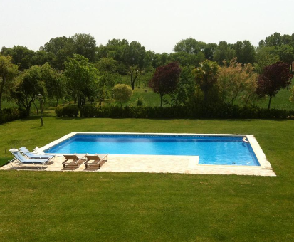 Piscina al aire libre ubicada en el jardín de la casa La Alberca en Palencia