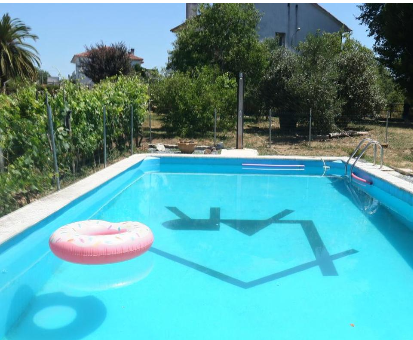 Piscina rectangular exterior ubicada al lado del huerto de la Casa Rural La Arbolada en Bóveda