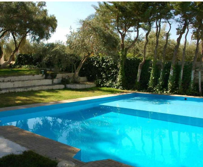 Piscina al intemperie localizada en el centro del jardín de la Casa Rural La Cateta en Mancha Real