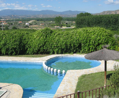 Piscina doble al aire libre con vista al pueblo de Benalúa Casa Rural La Granja