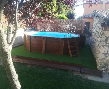 Piscina exterior de madera ubicada en el patio de la Casa La Loma en Nohales