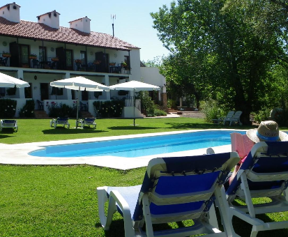 Piscina exterior ubicada en el centro del jardín de la Casa Rural La Media Legua en Aracena