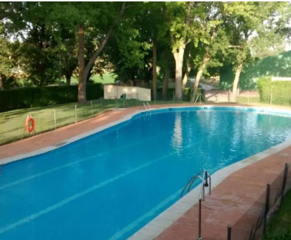 Piscina al aire libre cercada por una gran variedad de arboles y plantas hermosas. Casa Rural Las Albertas en Arbancón
