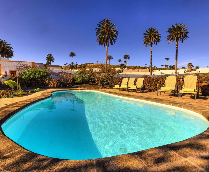 Hermosa piscina exterior rodeada de palmeras. Casa Rural Lola Y Juan en Haría