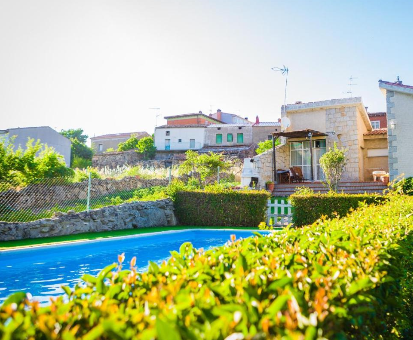 Piscina exterior rodeada de una hermosa diversidad de plantas de la Villa Los Chendas en Villanueva de Ávila 