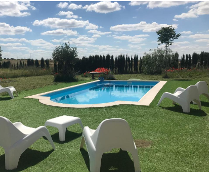 Piscina exterior ubicada en el medio del jardín Casa Rural Los Mineros en Villanueva del Duque