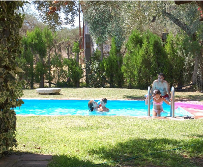 Piscina exterior familiar rodeada de un basto jardín. Hacienda Los Olivos en Aznalcázar