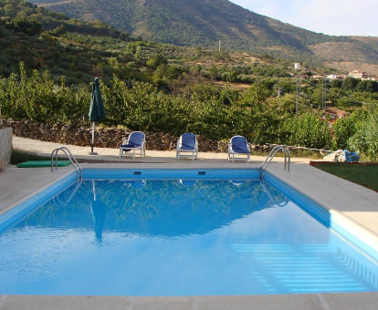 Piscina exterior con hermosa vista hacia el valle de Casas del Monte en Casas Rurales Manolo