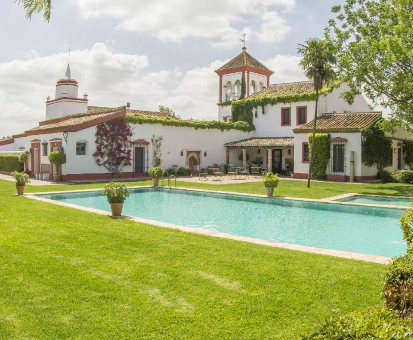Fantástica piscina exterior situada en el centro del jardín de la Hacienda Orán en Utrera