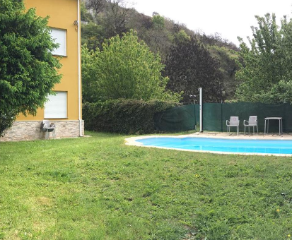 Piscina exterior situada en pleno jardín de la casa Os Arroxos en Trabadelo