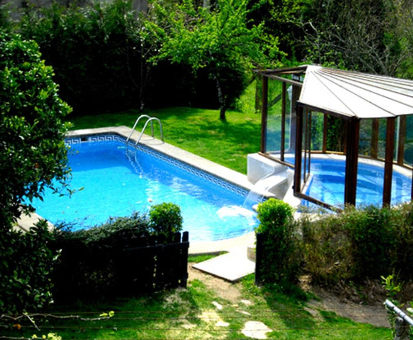Doble piscina al aire libre ubicada en el jardín de la Casa Rural Os Carballos en Pontevedra