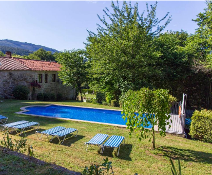 Piscina exterior situada en el jardín de la casa Pazo Larache en Santa Cristina de Cobres