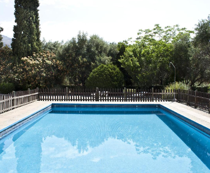 Piscina al intemperie rodeada de hermosas plantas y flores de la casa Cortijo Puerta Casas en Órgiva