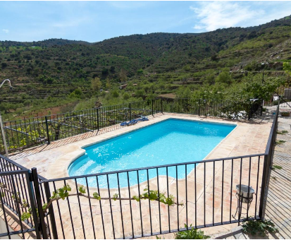 Piscina al aire libre ubicada en la terraza y con vista a la verde vegetacion del lugar Casa rural Reul Alto en Laroya